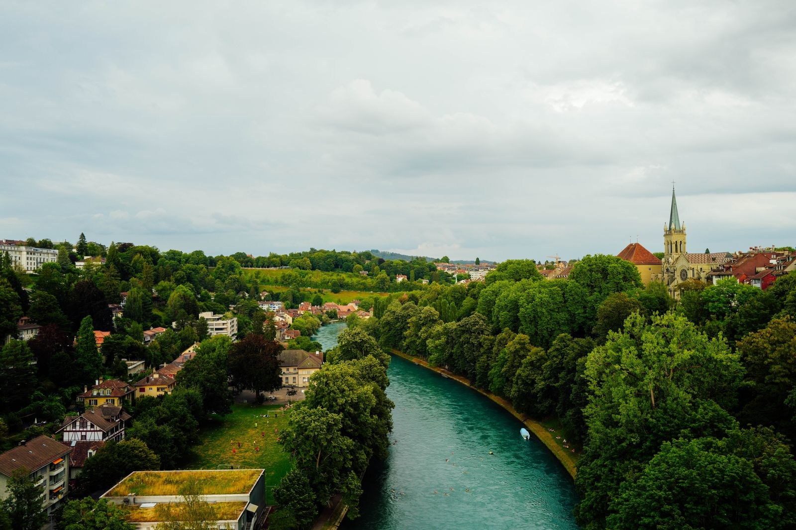 Die Aare zwischen grünen Ufern und Berner Häusern