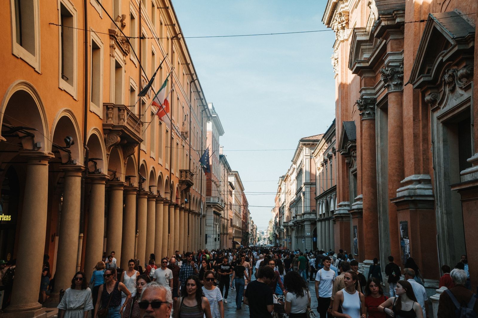 Belebte Straße mit Arkaden in Bologna
