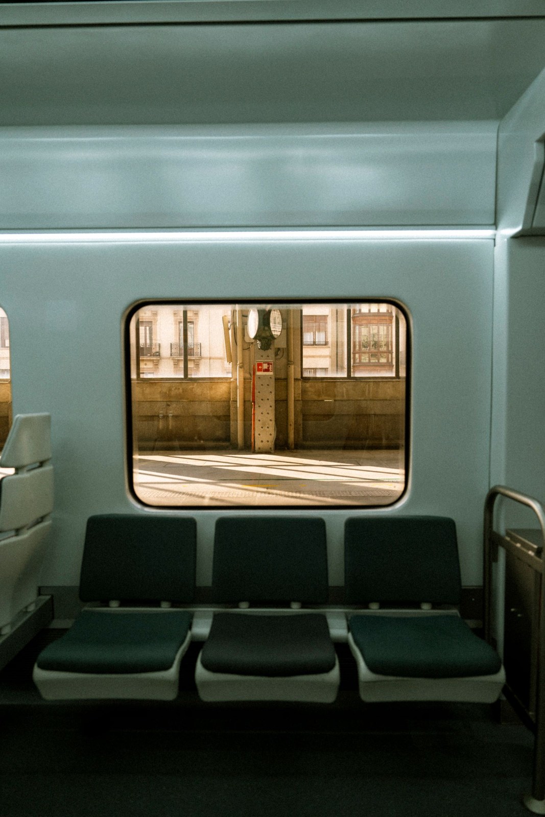 Leere Zugsitze vor einem Fenster mit Blick auf den Bahnsteig