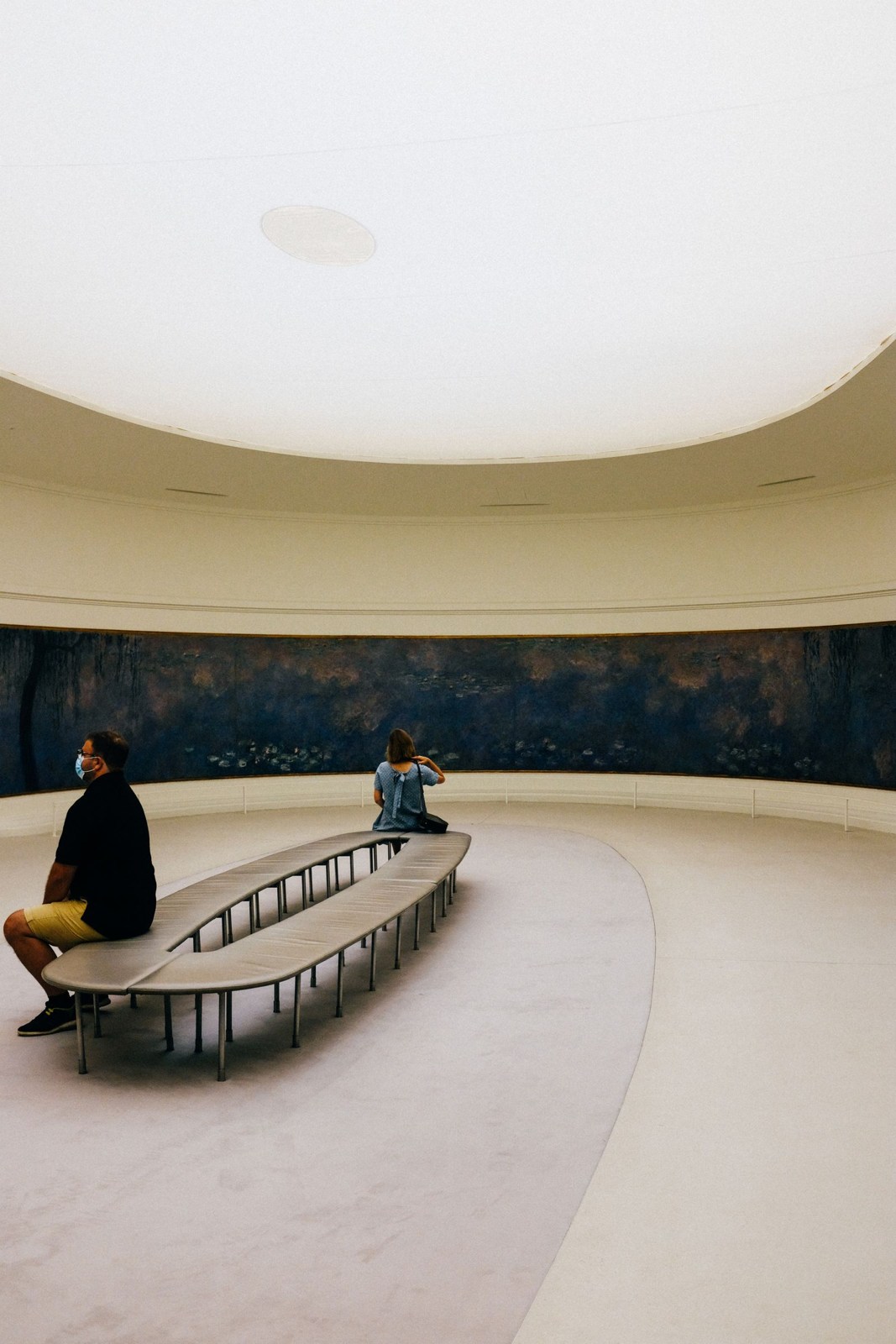 Besucher auf einer Sitzbank in einem Museumsraum