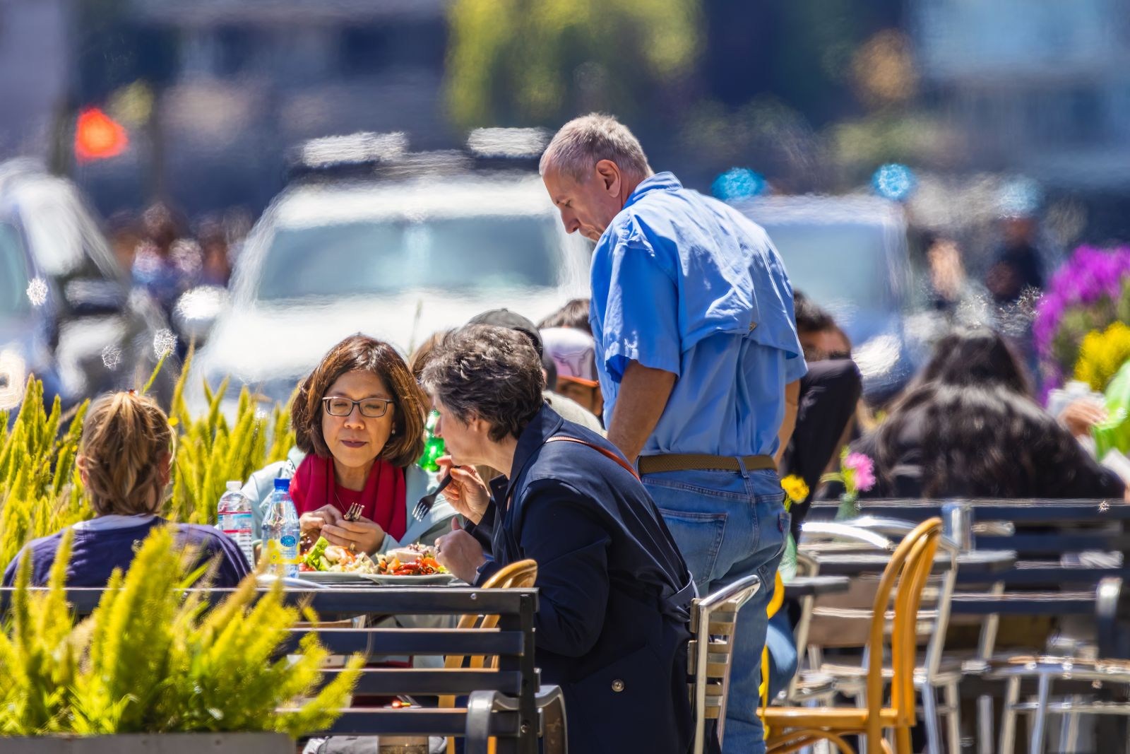 Menschen essen an Tischen vor einem Café