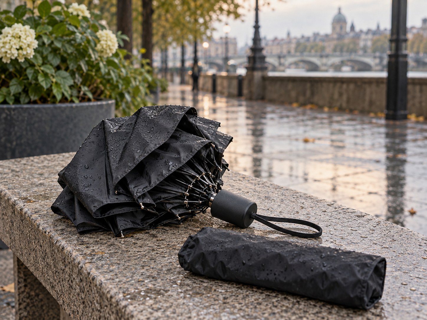 Faltbarer Regenschirm mit Hülle auf einer Bank