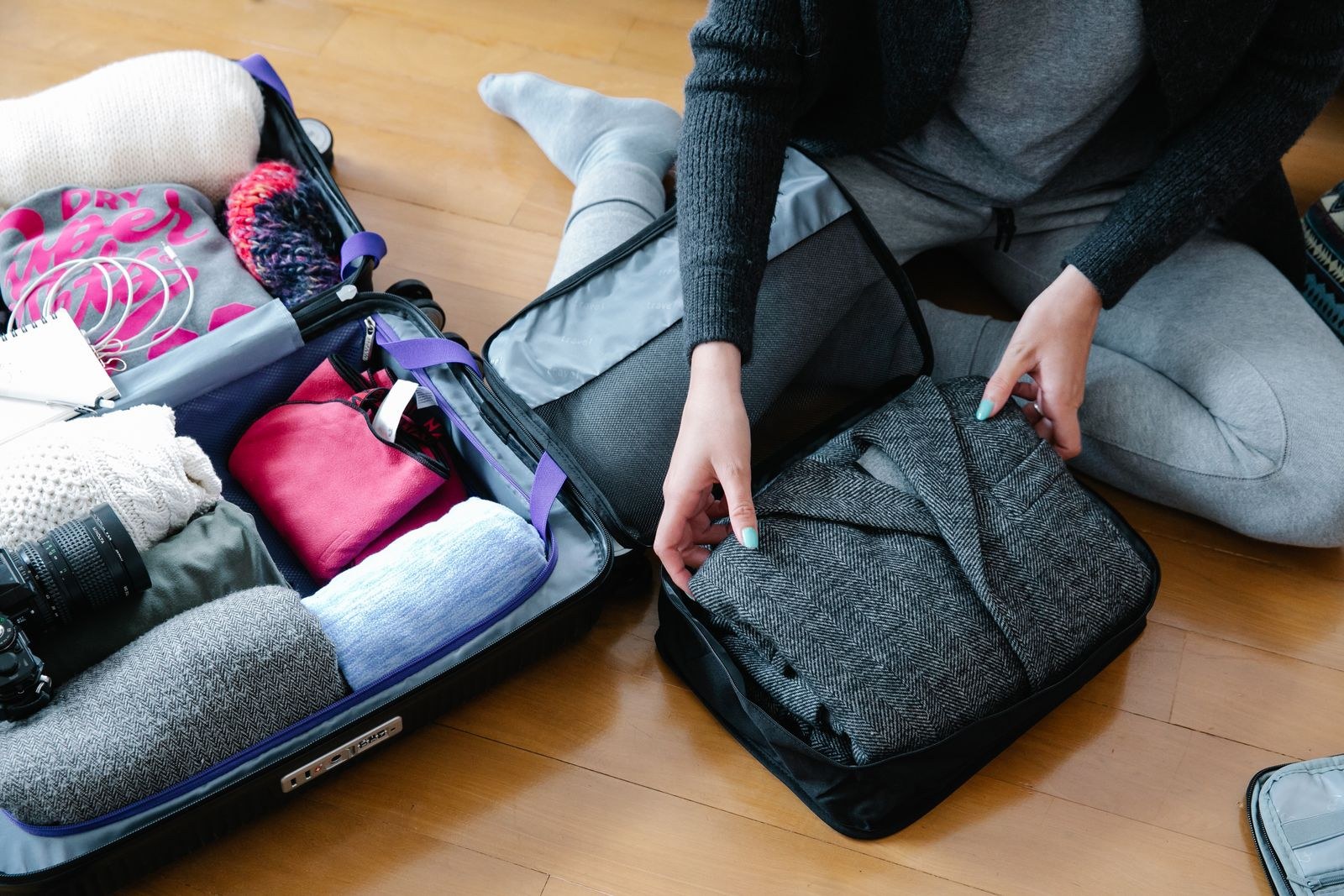 Reisende sortiert Kleidung und Ausrüstung vor dem Packen