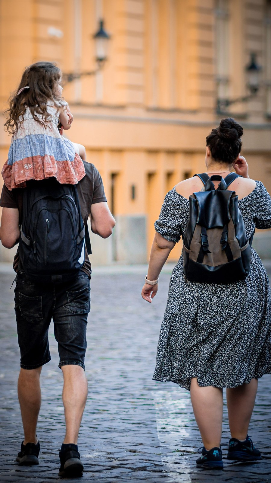 Familie mit Kind auf einer gepflasterten Stadtstraße