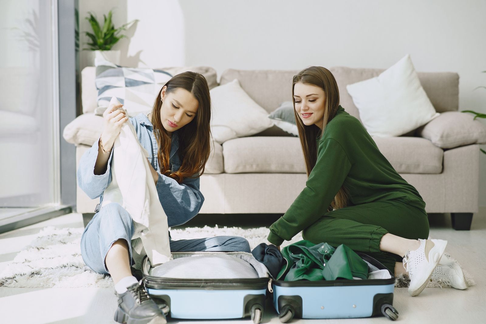 Zwei Reisende packen einen Koffer in ihrer Unterkunft aus