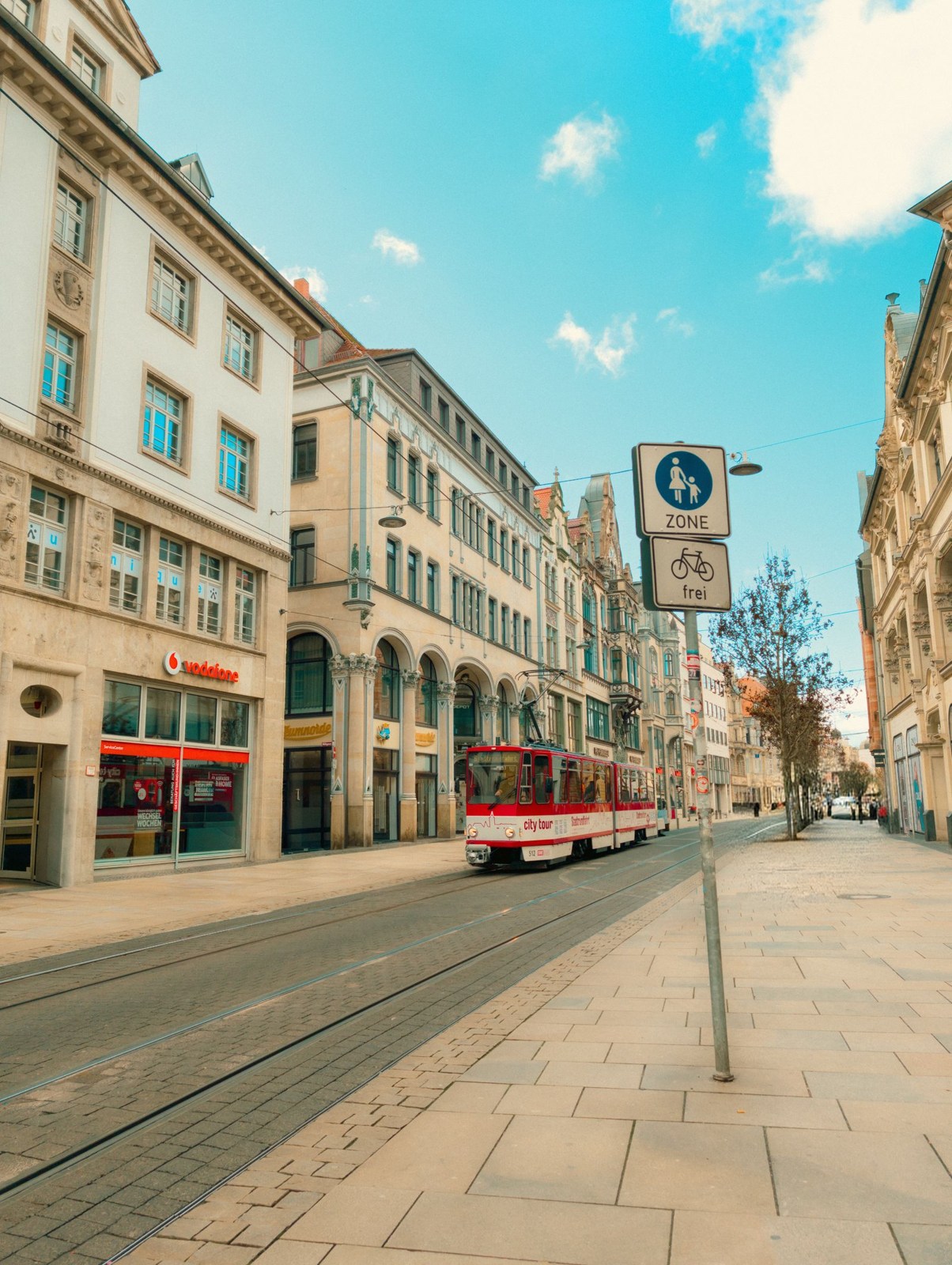Straßenbahn und Haltestelle zwischen städtischen Gebäuden